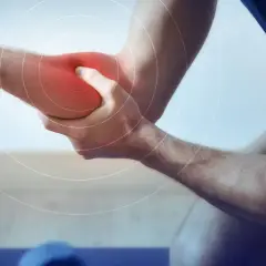 Un homme se tient le bras, une zone rouge vif sur son avant-bras indiquant une douleur. Des cercles concentriques suggèrent une gêne.