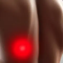 Gros plan sur le dos d'une personne, avec une zone rouge vif indiquant une douleur au dos gauche.