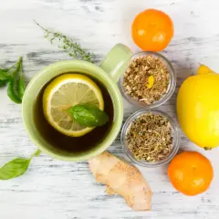 Tasse de thé au citron et herbes, gingembre, clémentines. Un remède de grand-mère pour le rhume de cerveau.