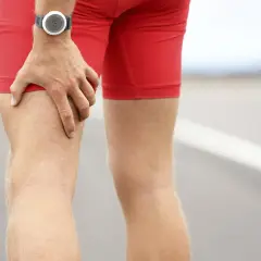 Un coureur s'arrête, une main sur sa cuisse, peut-être une douleur pointe derrière la cuisse.