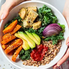 Un bol coloré avec patates douces, avocat, tofu, chou kale et oignon rouge. Une délicieuse alimentation anti cholestérol.