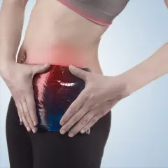 Femme appliquant une poche de glace sur sa zone douloureuse, symptomatique d'une pubalgie sans sport.