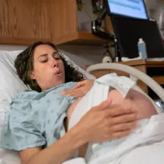 Femme en travail, le bébé engagé dans le bassin, respire profondément.