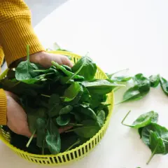 Des épinards frais dans un panier jaune, une aide naturelle pour savoir comment faire baisser le diabète sans médicament.