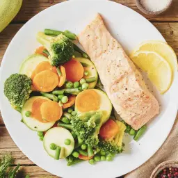 Un filet de saumon grillé avec un assortiment de légumes colorés, parfait pour un programme alimentaire perte de poids.