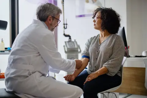 Un médecin prélève du sang pour vérifier le taux de chlore dans le sang d'une patiente.