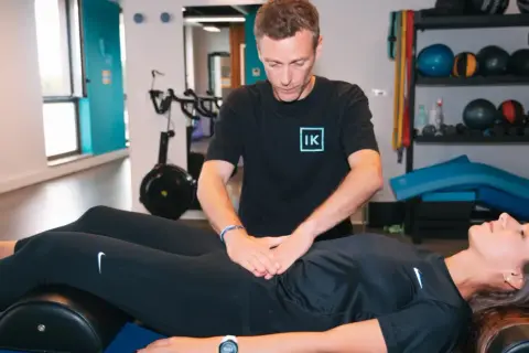 Thérapeute évaluant un diastasis abdominal avant et après, sans chirurgie.