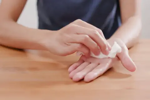 Main moite remède de grand-mère : une personne nettoie ses mains avec une lingette humide, un geste simple pour une hygiène parfaite.