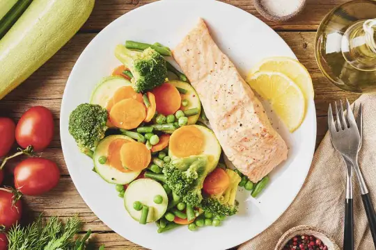 Un filet de saumon grillé avec un assortiment de légumes colorés, parfait pour un programme alimentaire perte de poids.