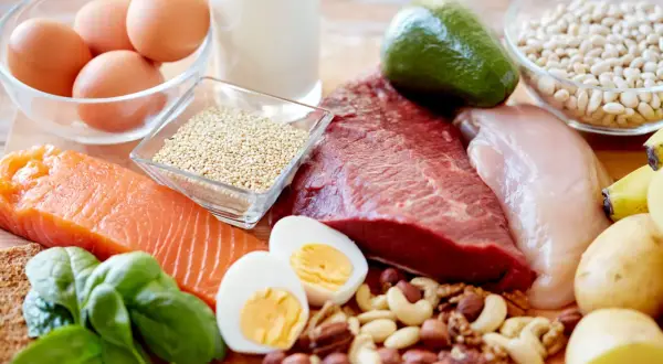 Assortiment d'aliments riches en protéines : saumon, bœuf, poulet, œufs, quinoa, noix, haricots, avocat, épinards, lait, bananes et pommes de terre. Un vrai festin pour la santé, y compris pour l'aliment pour les cheveux.