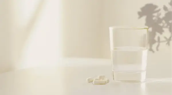 Verre d'eau et gélules. La mélatonine 1.9 mg effets secondaires potentiels sont une préoccupation pour certains.