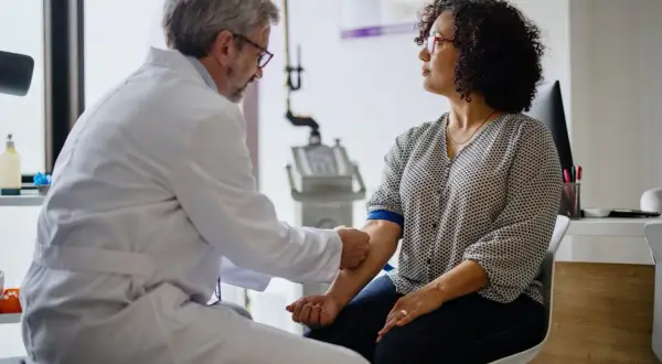 Un médecin prélève du sang pour vérifier le taux de chlore dans le sang d'une patiente.
