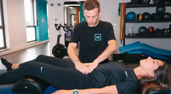 Thérapeute évaluant un diastasis abdominal avant et après, sans chirurgie.