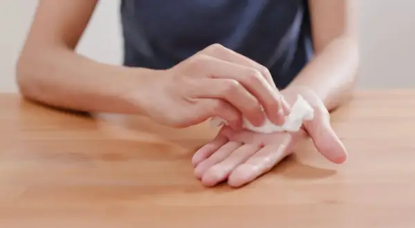 Main moite remède de grand-mère : une personne nettoie ses mains avec une lingette humide, un geste simple pour une hygiène parfaite.