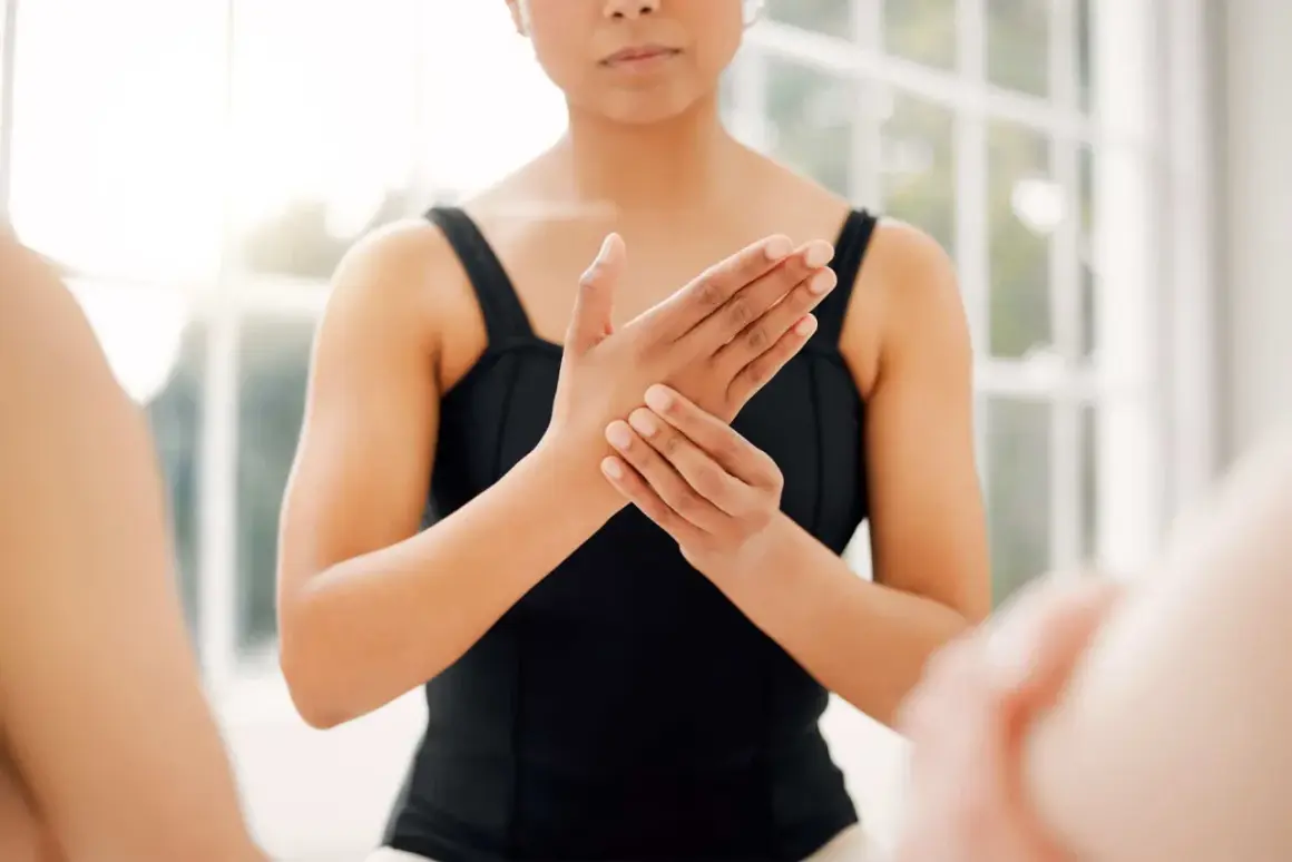 Une danseuse se tient la main droite, le petit doigt semble lui causer une douleur.