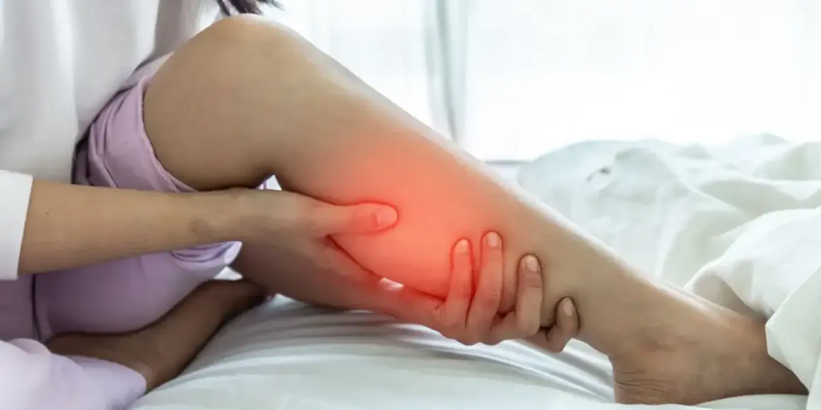 Une personne se tient la jambe, le mollet dur et gonflé, avec une zone rouge indiquant la douleur.