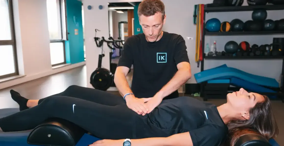 Thérapeute évaluant un diastasis abdominal avant et après, sans chirurgie.