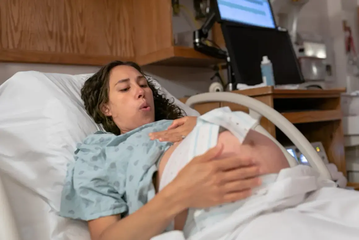 Femme en travail, le bébé engagé dans le bassin, respire profondément.