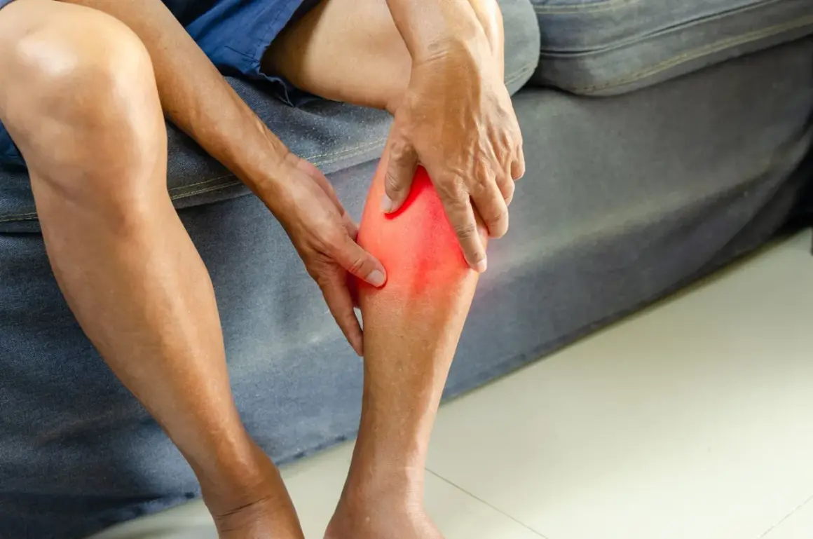 Main tenant sa jambe, une personne ressent une douleur vive, se demandant combien de temps d'arrêt de travail pour une déchirure musculaire.