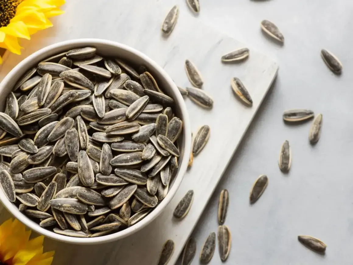 Un bol rempli de graines de tournesol, rappelant les nombreux bienfaits de ce superaliment. Quelques graines sont éparpillées autour.