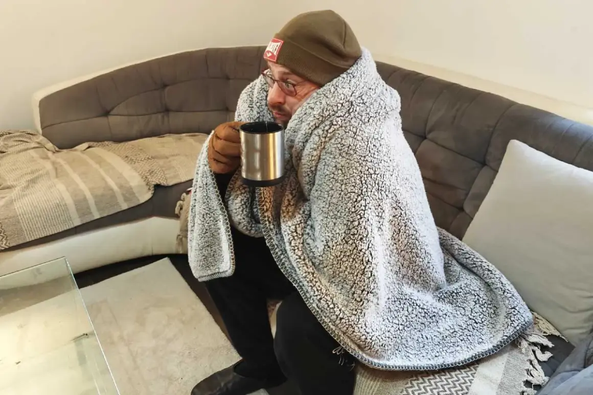 Un homme emmitouflé dans une couverture, tenant une tasse chaude, se demande pourquoi j'ai froid alors qu'il fait chaud.