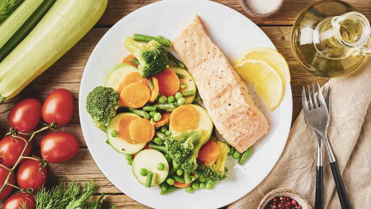 Un filet de saumon grillé avec un assortiment de légumes colorés, parfait pour un programme alimentaire perte de poids.