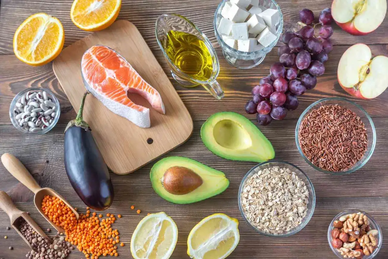 Assortiment d'aliments sains : saumon, avocat, fruits, légumes, noix, riz, avoine, lentilles. Idéal pour un régime contre le mauvais cholestérol.