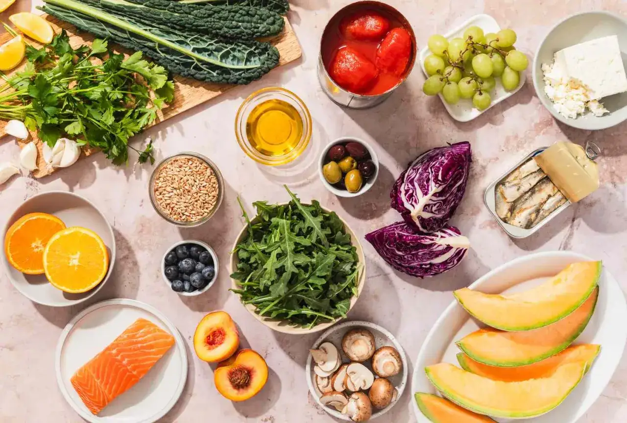 Ingrédients pour un régime anti cholestérol : saumon, légumes verts, fruits, huile d'olive, sardines, et autres aliments sains.