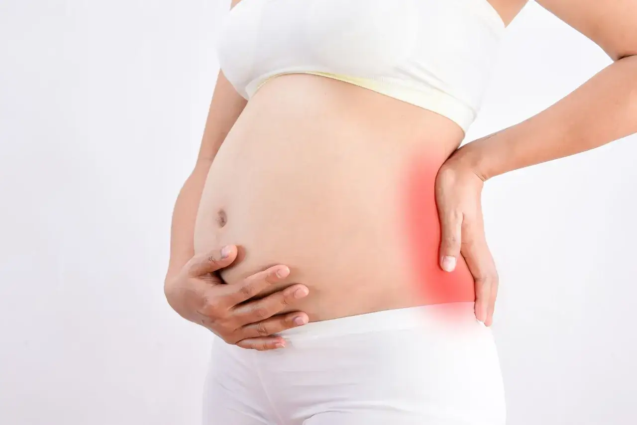 Femme enceinte, fin de grossesse, douleur au fessier et au bas du dos, zone rouge indiquant la douleur.