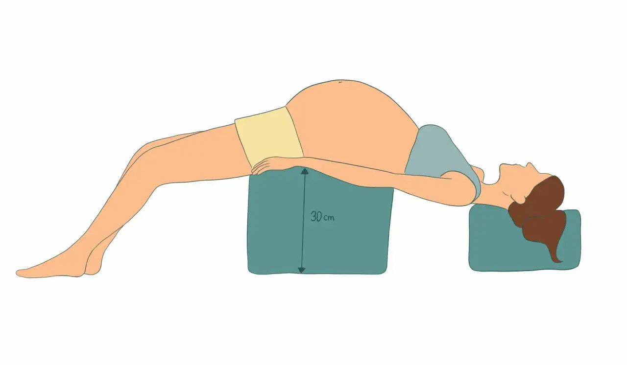 Schéma d'une femme enceinte en position allongée sur des coussins pour soulager la douleur ligamentaire de grossesse.