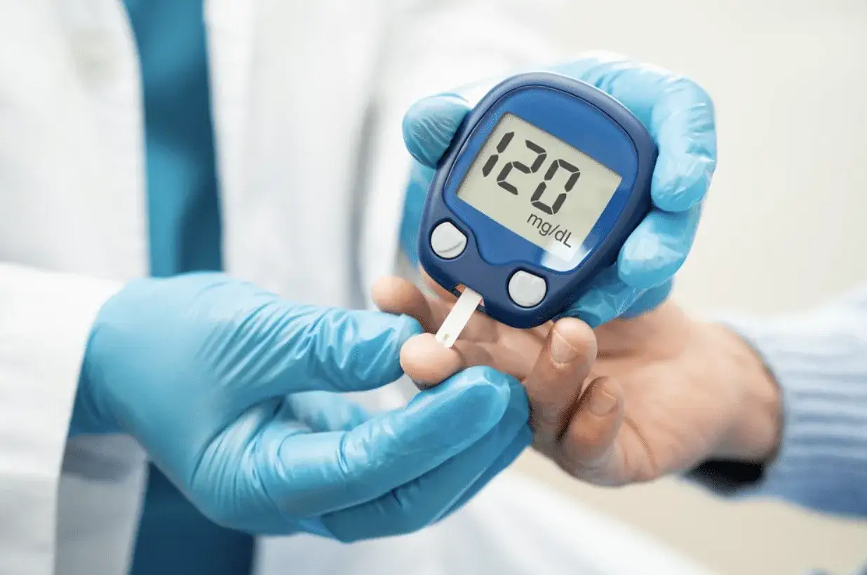 Main tenant, avec un glucomètre, mesure sa glycémie. Le résultat affiche 120 mg/dL. Que faire en cas de diabète ?