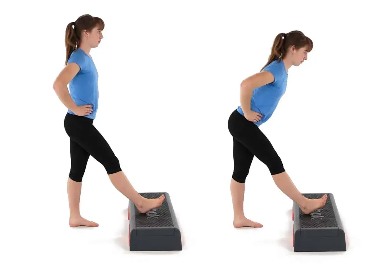 Jeune femme s'étirant la jambe sur un step. Un ischio-jambier raide peut être la conséquence d'un manque de souplesse.