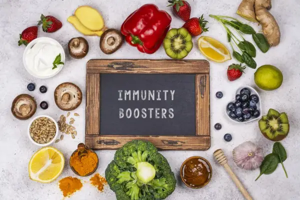 Assortiment d'aliments colorés : fraises, kiwis, brocolis, citron, curcuma, ail, gingembre, myrtilles, champignons, poivron rouge, épinards, graines de tournesol, yaourt. Ces aliments sont excellents pour le système immunitaire.