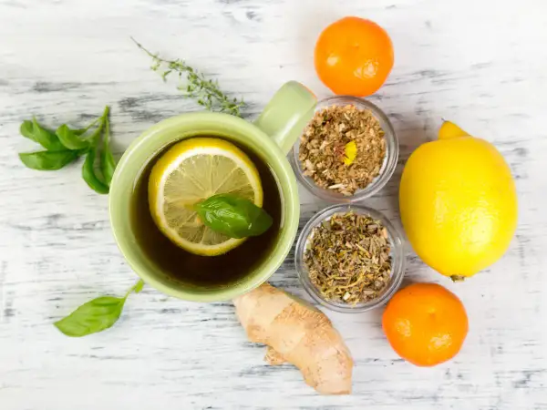 Tasse de thé au citron et herbes, gingembre, clémentines. Un remède de grand-mère pour le rhume de cerveau.