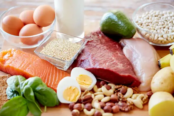Assortiment d'aliments riches en protéines : saumon, bœuf, poulet, œufs, quinoa, noix, haricots, avocat, épinards, lait, bananes et pommes de terre. Un vrai festin pour la santé, y compris pour l'aliment pour les cheveux.